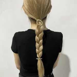 Detailed view of minimalist gold alloy hair clip and ponytail cuff on braided hair