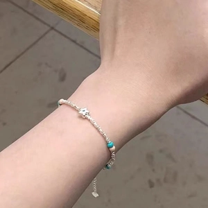 Close-up of minimalist beaded bracelet with silver star charm and colorful beads