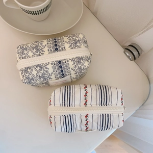 French floral quilted cotton cosmetic bags on a desk with a coffee cup accessory