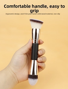 Detail of dual-ended makeup brush with matte black wood handle and rose gold ferrule