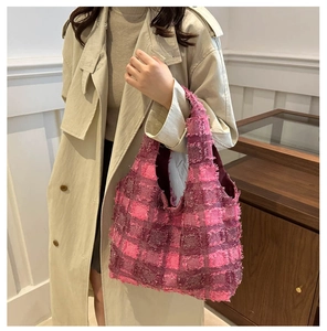 Pink and deep burgundy plaid tweed tote bag with fringe details on a beige trench coat