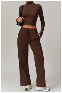 Detail of high-neck crop top and drawstring wide-leg yoga pants in dark brown matte fabric