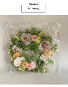 Pink and blue artificial spring wreath with floral patterns in clear plastic packaging