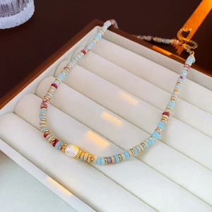 Detail of beaded pearl necklace with blue and brown beads in a premium jewelry box
