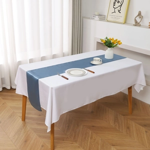 Close-up of a blue satin table runner on a white tablecloth with yellow tulips