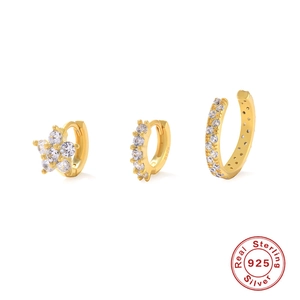 Detail of three-piece 925 silver gold earrings with S925 hallmark and sparkling cubic zirconia
