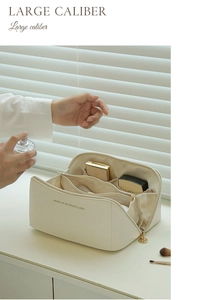 Detail of a large-capacity cream makeup bag with internal compartments and gold zipper