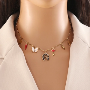 Gold stainless steel necklace with butterfly, horseshoe, and heart charms on a model