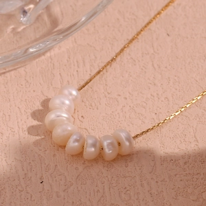 Detalle de cadena de acero bañada en oro 18K con ocho perlas naturales de agua dulce