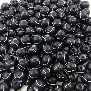 Close-up of black acrylic tennis-patterned beads with drill holes for DIY jewelry