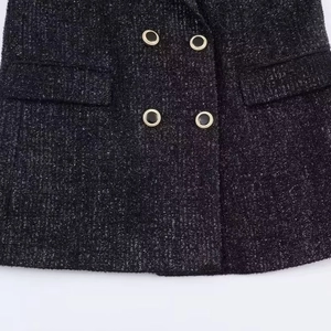 Women's black tweed blazer featuring golden buttons and detailed textured fabric