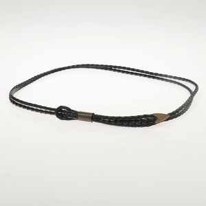 Detail of black braided leather belt with antique bronze bull head metal buckle and tip