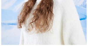 Close-up of white plush faux fur texture on a winter hooded knit hat with a warm fuzzy feel