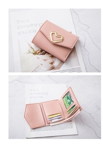 Pink tri-fold leather wallet featuring gold heart clasp, multiple card slots and photo window