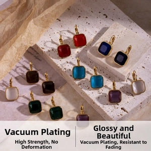 Vue macro de boucles d'oreilles carrées en zircon coloré et placage d'or sur papier vintage