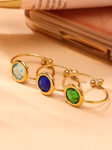 Detail von drei 18k vergoldeten verstellbaren Ringen mit blauen und grünen Glassteinen