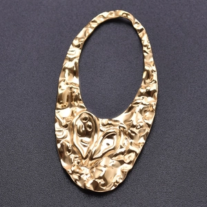 Detailed view of irregular oval hollow pendant with golden hammered texture for DIY jewelry
