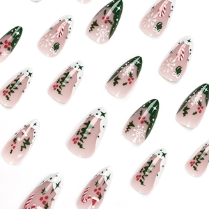 Christmas press-on nails with green and white snowflake patterns on long almond shape