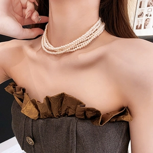 Detailansicht einer mehrlagigen Kunstperlen-Halskette getragen am Hals für einen Modetrend