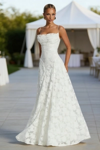 Detail of white floral jacquard fabric and thin straps on the slim wedding dress