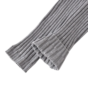 Close-up of grey ribbed knit texture and folded cuff detail on a slim fit sweater