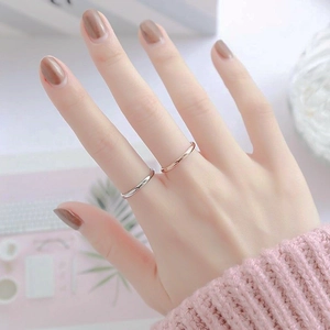 Minimalist gold and silver titanium steel rings worn on fingers in a professional setting