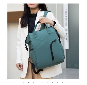 Deep teal multifunctional diaper backpack with ergonomic straps shown on street model