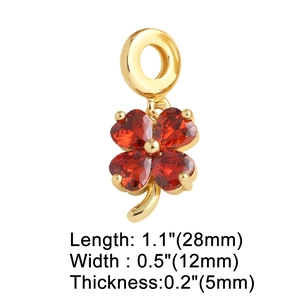 Detail view of gold clover pendant with red stone showing 28x12mm dimensions