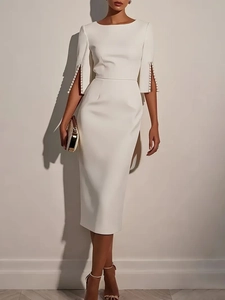 Close-up of elegant white dress featuring sophisticated pearl embellishments on slit cuffs