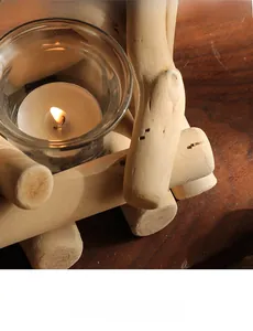 Detalle de portavelas rústico de madera con vidrio y cálida luz de vela encendida