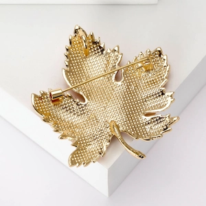 Luxurious maple leaf brooch back view with gold dotted texture and secure pin clasp closure