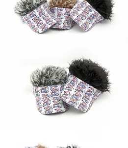 Close-up of novelty visor hats with colorful spiky wigs and star-patterned brims