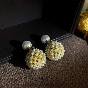 Exquisite gold-plated pearl cluster stud earrings on a dark textured background