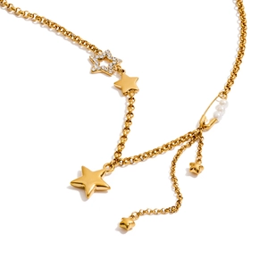 Collana in acciaio dorato con stelle e ciondolo spilla a perle su sfondo bianco