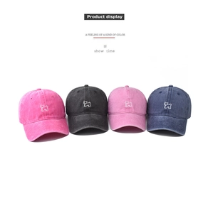 Gros plan de quatre casquettes en coton lavé avec motifs de chien brodés en plusieurs couleurs