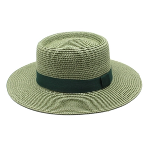 Detail of green straw boater hat with wide flat brim and dark green ribbon band