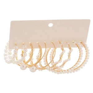 Vintage French gold hoop earrings set with pearls and textured beads on white background