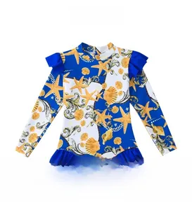 Detail of girls long sleeve swimsuit with blue baroque ocean prints and ruffled trims