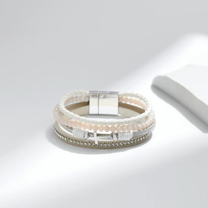 Close-up of multilayer white PU leather bracelet with pink beads and silver cross charm