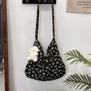 Close-up of floral cotton tote bag with heart print and cute sheep plush charm on wall