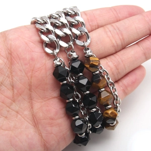 Stainless steel chain bracelet with natural black onyx and tiger eye beads on a wrist