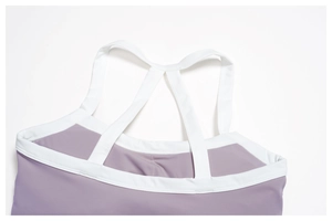Détail du soutien-gorge de yoga à dos croisé en violet avec bordure contrastée blanche