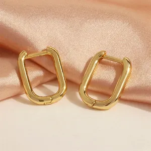 Detail of 18K gold plated U-shaped rectangular hoop earrings on champagne silk fabric