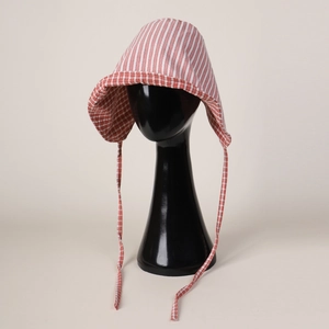 Close-up of red and white striped baby bonnet with checkered lining and chin ties