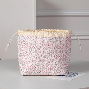Close-up of floral quilted drawstring pouch with intricate diamond stitching and cotton fabric