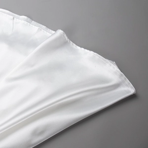 Close-up of white satin skirt hem showing smooth silk texture and fine stitching detail