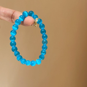 Close-up of blue cat eye stone beads on a single-strand minimalist bracelet