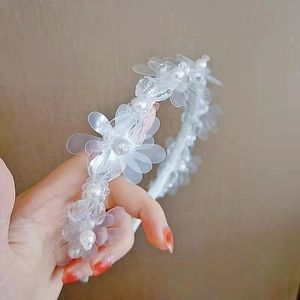 Detail shot of elegant white flower headband with transparent petals and pearls