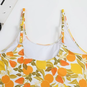 Detail of adjustable shoulder straps with silver buckles on a fruit print swimsuit