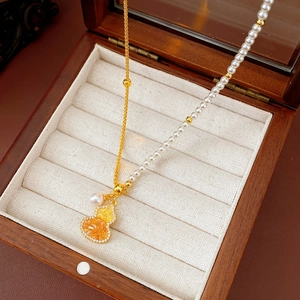 Vue détaillée du pendentif gourde plaqué or 18 carats avec pierre jaune et perles